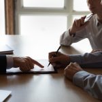 Lawyer showing a couple where to sign illustrating the process of utilizing Delaware Statutory Trusts for tax deferral in a 1031 exchange